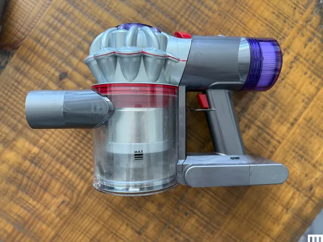 Overhead view of Dyson Car+Boat Handheld Vacuum on top of a wooden table.